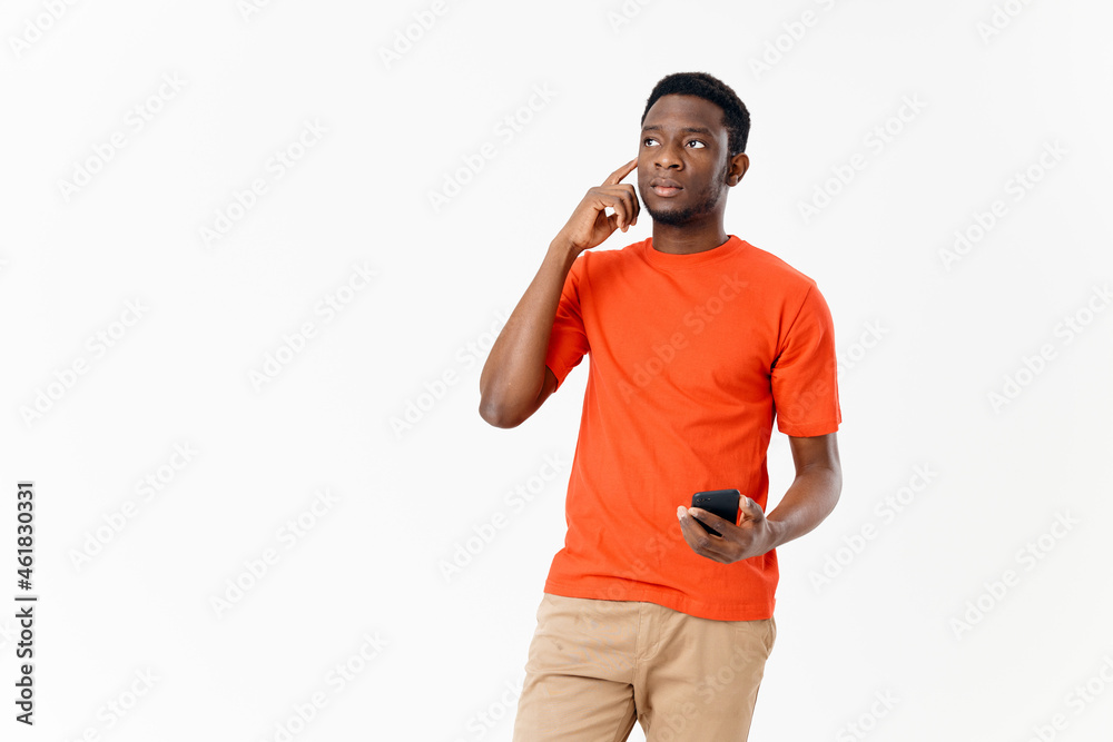 Fototapeta premium cute African American in a t-shirt and shorts with a mobile phone 