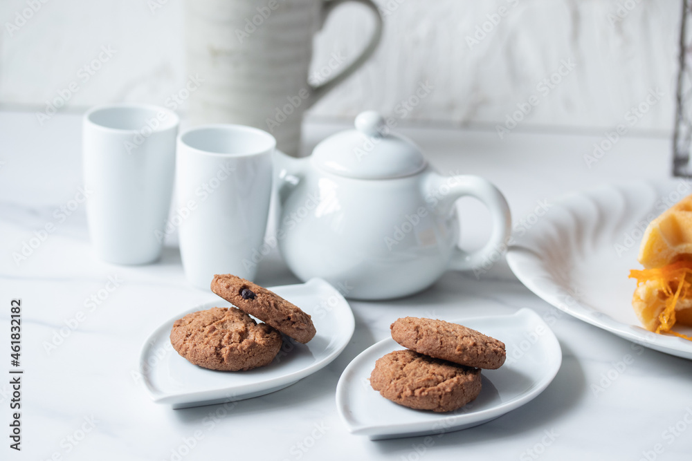 Cookies in a white plate, teapot, afternoon snack. Cookies in a white plate, teapot, afternoon snack.
