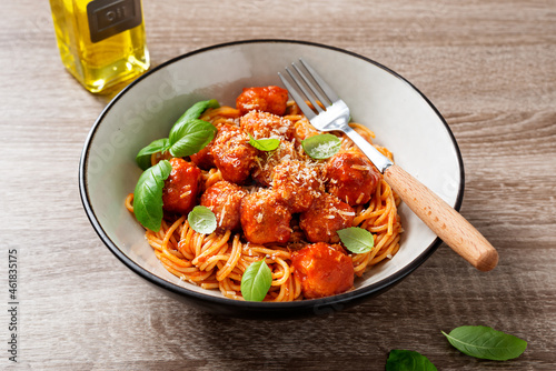 Spaghetti pasta portion with meatballs and tomato sauce. Wooden background.