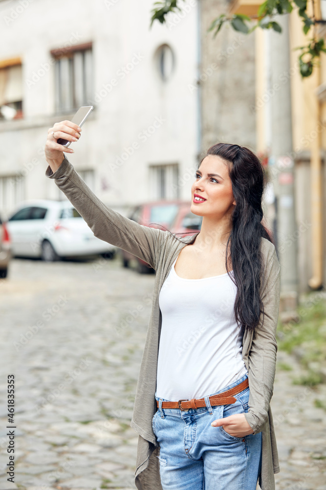 Young cute female using smartphone on the street. Young cute female using smartphone on the street.