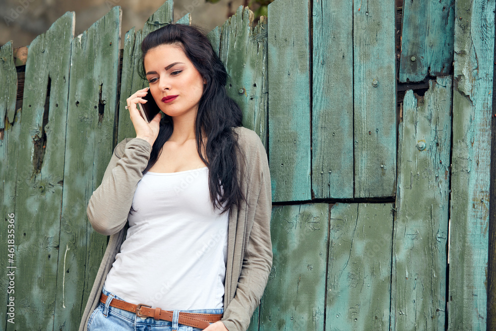 Obraz premium Young cute female using smartphone on the street.