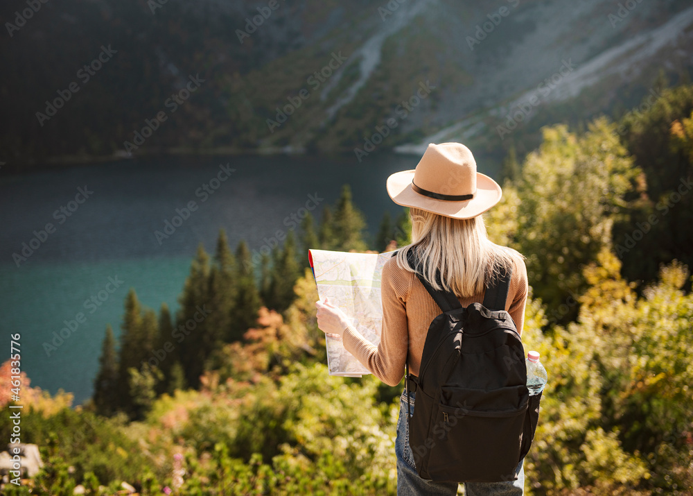 Woman traveler wearing hat and looking at amazing mountains and lake