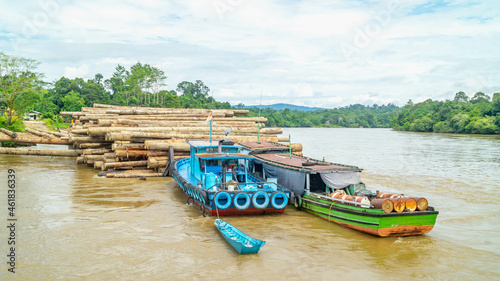 Timber loaded into big barge then drag by a tugboat cruising Mahakam River, Borneo, Indonesia