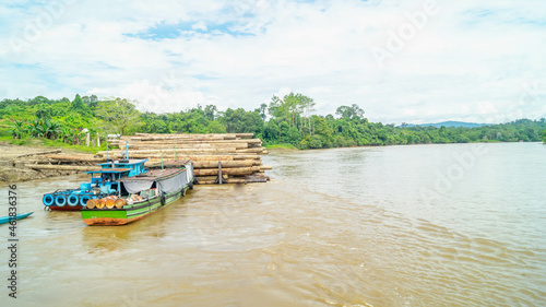 Timber loaded into big barge then drag by a tugboat cruising Mahakam River  Borneo  Indonesia