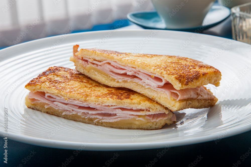 Delicioso sándwich cortado por la mitad con jamón y queso a la plancha, ham and cheese sandwich Delicioso sándwich cortado por la mitad con jamón y queso a la plancha, ham and cheese sandwich