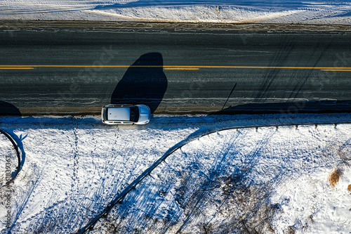 Aerial top-down view of a car on the road in winter season