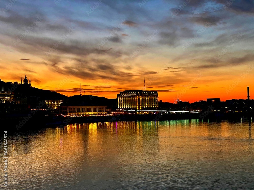 Orange red sunset over Dnieper river . Evening Kiev town view. Beautiful cityscape of Kyiv city at night. Urban skyline at dusk. Orange red sunset over Dnieper river . Evening Kiev town view. Beautiful cityscape of Kyiv city at night. Urban skyline at dusk.