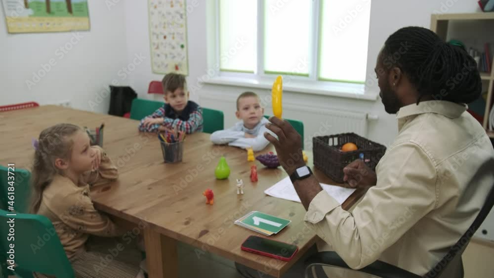 An African American teacher and a group of children are studying fruits and animals in the classroom.School for Children, Teaching Adolescents, Gain Knowledge, Learn the Language. An African American teacher and a group of children are studying fruits and animals in the classroom.School for Children, Teaching Adolescents, Gain Knowledge, Learn the Language.