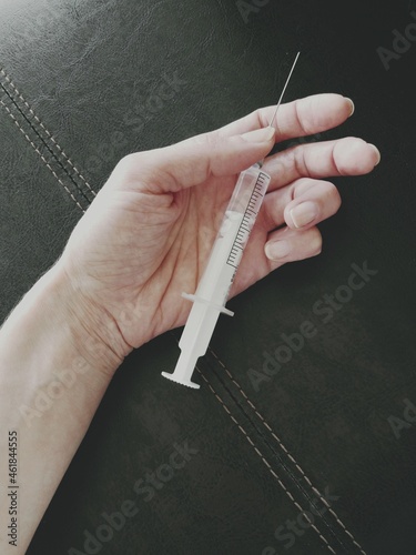 Weak hand of drug addict with syringe 