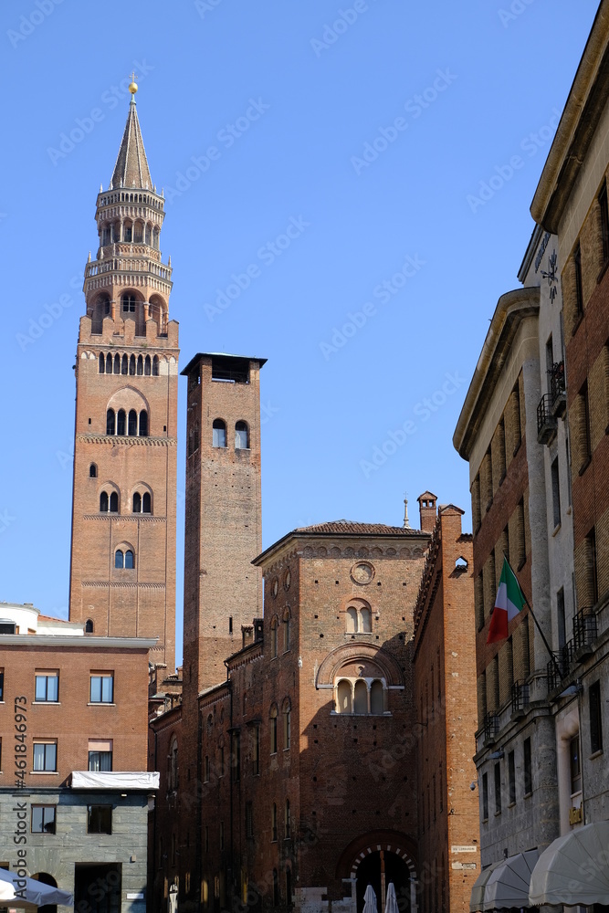 Torrazzo of Cremona. Torrazzo of Cremona and ancient palaces.A street in the center with the tall bell tower with clock, symbol of the city, made of bricks. 