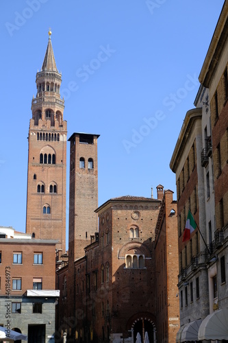 Torrazzo of Cremona. Torrazzo of Cremona and ancient palaces.A street in the center with the tall bell tower with clock, symbol of the city, made of bricks. 