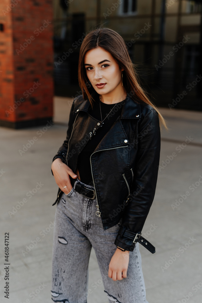 Beautiful young woman in black leather jacket posing on the street Beautiful young woman in black leather jacket posing on the street