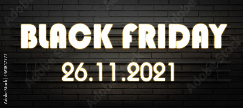 neon sign with message BLACK FRIDAY and the 2021 date on a dark brick wall background