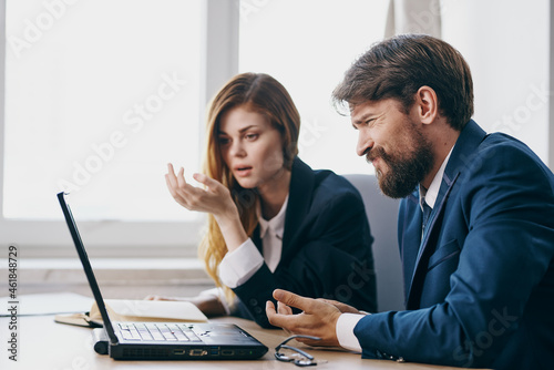 colleagues sitting in front of a laptop teamwork officials