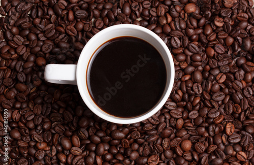 Vista de una taza de café blanco sobre un fondo de granos de café