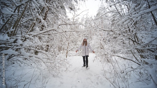 A teenage girl walks through the snowy forest. © Довидович Михаил