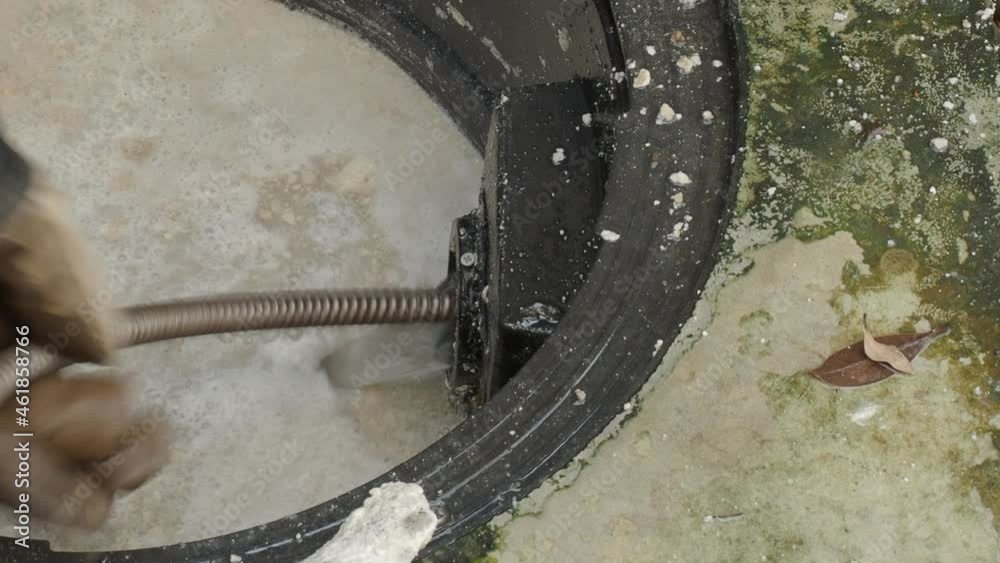 Video Stock Drain cleaning. Plumber repairing clogged grease trap with