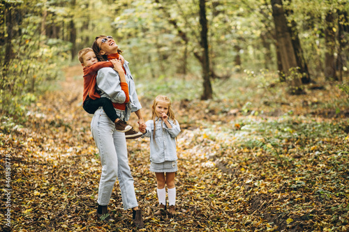 Mother with her little son and daughter in an autumn park