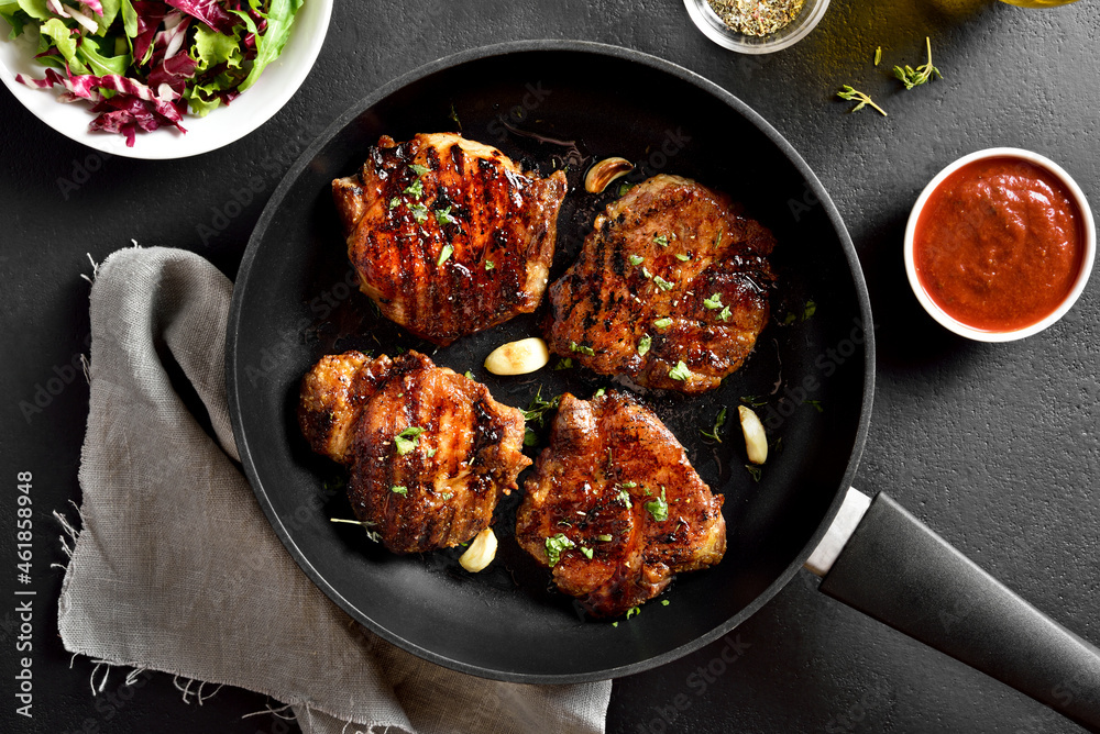 Fried pork steaks in frying pan Fried pork steaks in frying pan