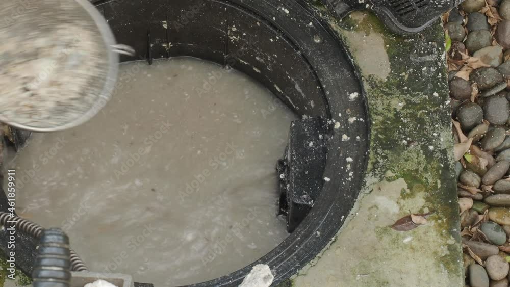 Drain cleaning. Plumber repairing clogged grease trap with auger