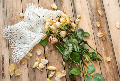 Trockene Rosen auf Untergrund aus Holz mit Spitzendecke     Bl  ten und Bl  tter