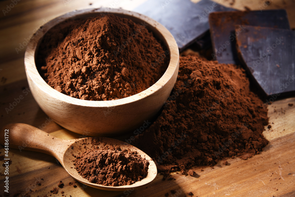 Composition with bowl of cocoa powder on wooden table Composition with bowl of cocoa powder on wooden table
