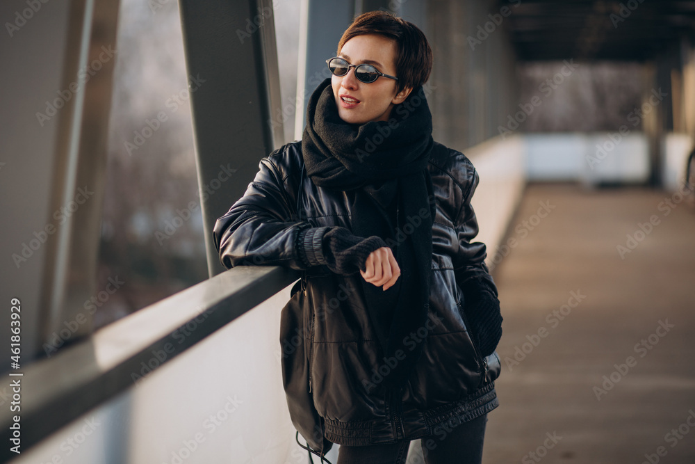 Woman in black jacket walking through the bridge Woman in black jacket walking through the bridge