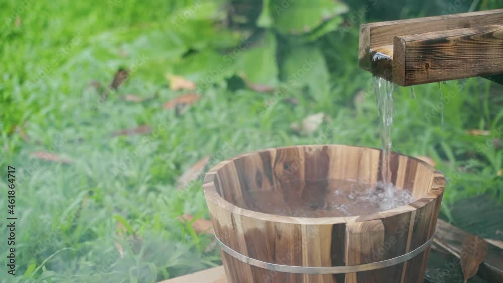 Wooden bucket for foot bath in hot spring garden, onsen, soft-focus.4k Wooden bucket for foot bath in hot spring garden, onsen, soft-focus.4k