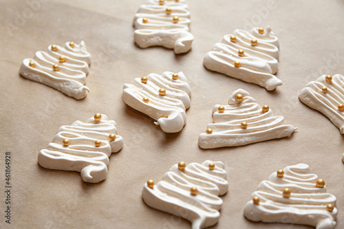 Ciasteczka w kształcie choinki na święta Bożego Narodzenia, słodkie bezy z cukrem i posypką cukrową. 