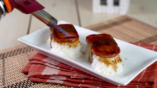 Spam musubi is a popular snack and lunch food in Japan that composed of spam on top of rice wrapped with thick or thin nori photo