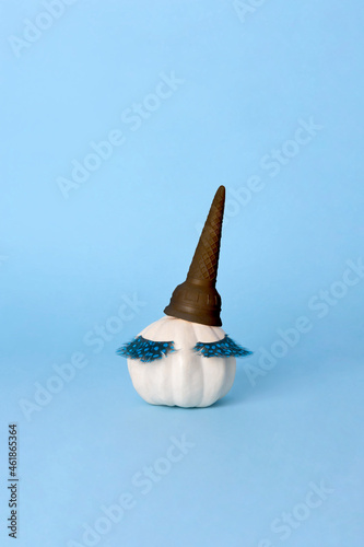 White Halloween pumpkin with make up on the blue background. Minimal Holiday season concept background.