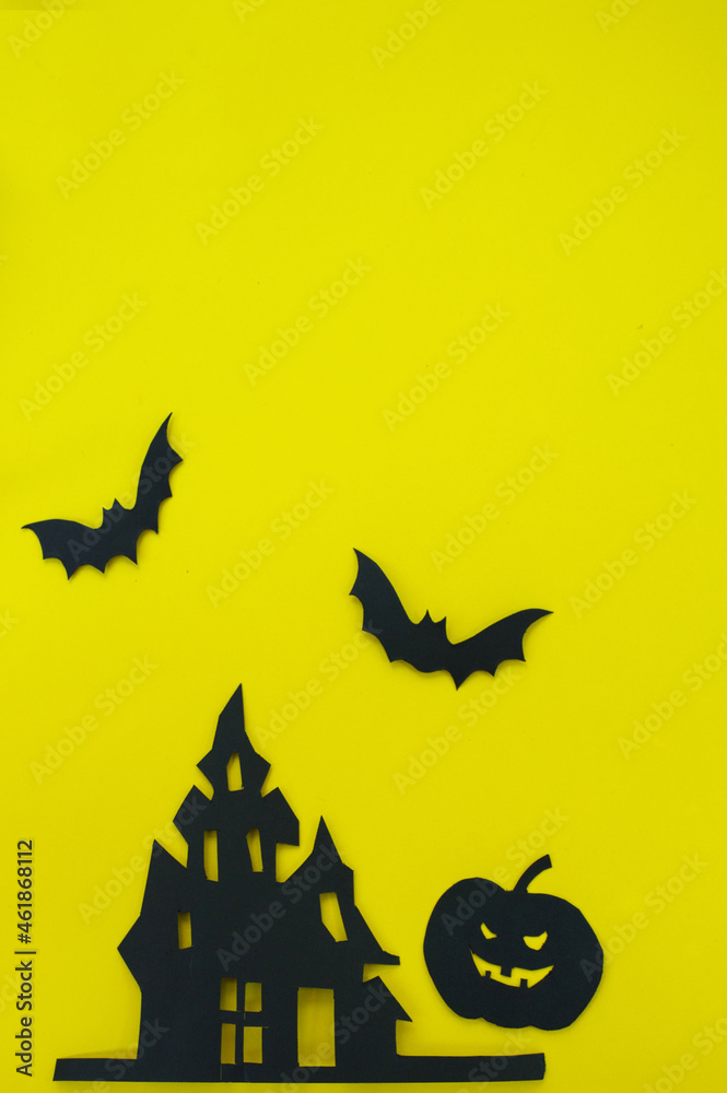 Halloween and decoration concept - bats, pumpkins, gloomy paper house, gloomy black tree branches on a yellow background. Folded paper origami art.
Halloween background with cut out
bats and other dec