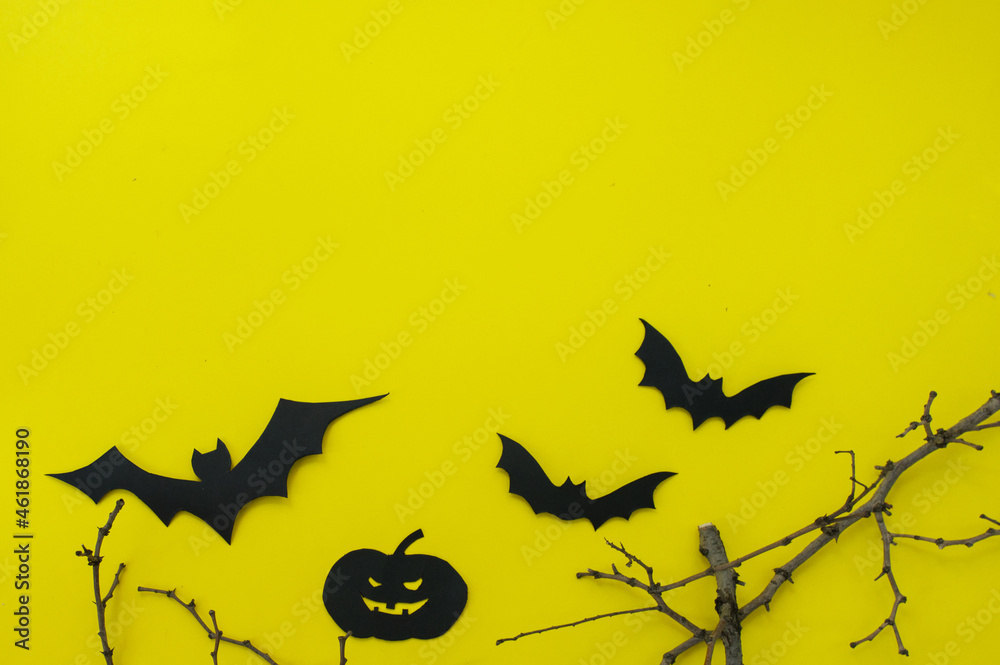 Halloween and decoration concept - bats, pumpkins, gloomy paper house, gloomy black tree branches on a yellow background. Folded paper origami art.
Halloween background with cut out
bats and other dec