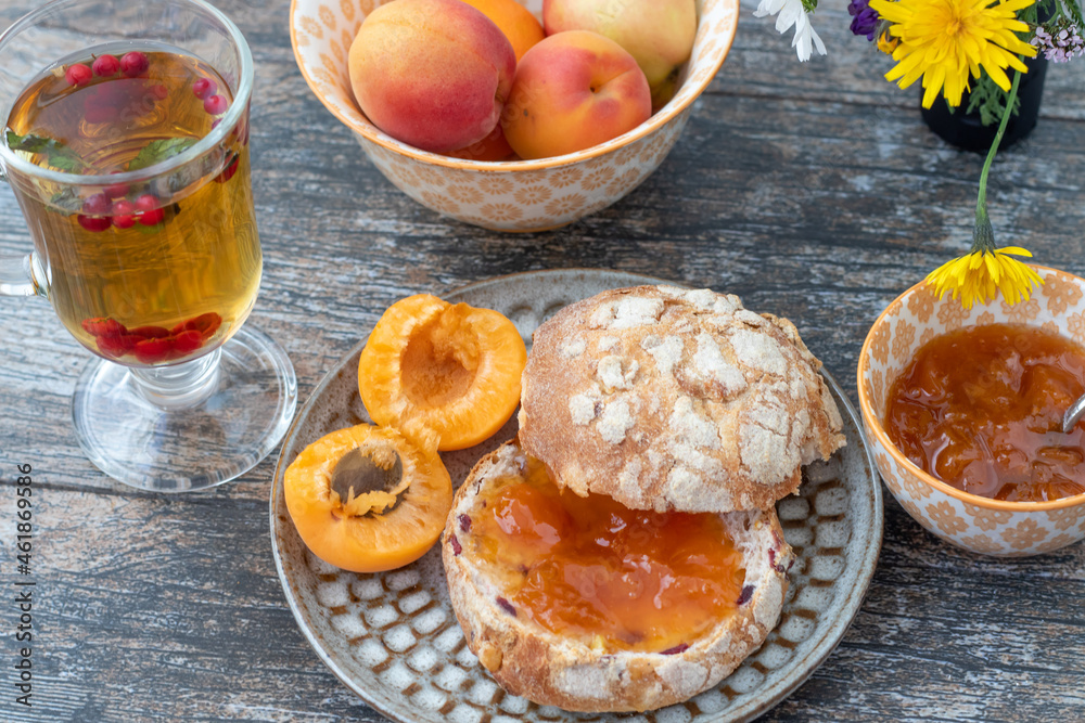Breakfast with fresh baked bread and apricot jam and berries tea Breakfast with fresh baked bread and apricot jam and berries tea