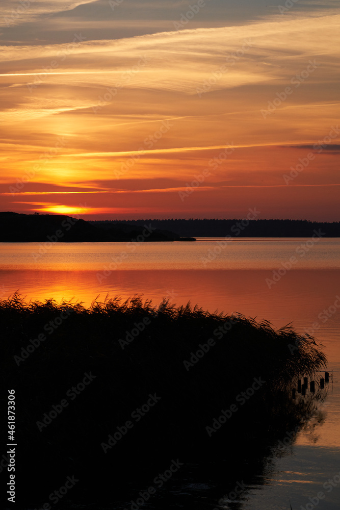 Colourful sunset at lake Flyndersoe in Denmark with the sky reflecting in the lake on a silent evening