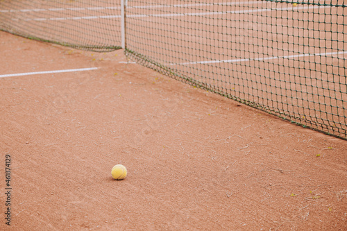 Empty clay tennis court. Tennis balls near net. White stripes. Dry grass. © Anastasia