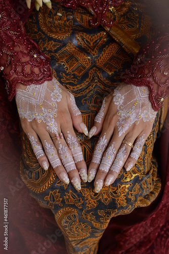 Traditional Javanese Women's Hands wearing henna and rings. Hands with beautiful Henna. new fullhand style mehndi. Close up view of Bride showing mehndi jewelry. mehendi painted on girl's hand.