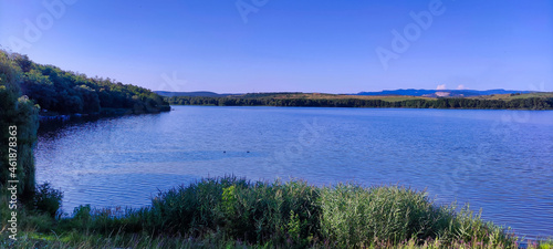 Reeds at Rakaca Reservoir. Lake and Trees. Shore and mountains in the background. Szalonna. Hungary. Europe 