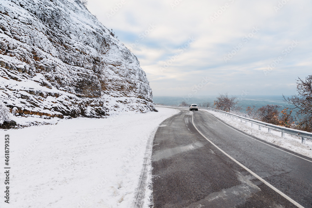 Winter time with snow trees, road with automobile and ocean at background. Winter landscape Winter time with snow trees, road with automobile and ocean at background. Winter landscape