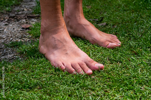 Young man's bare feet on the grass