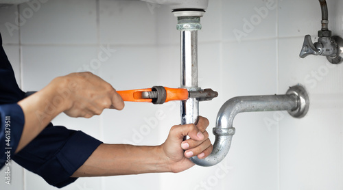 plumber at work in a bathroom, plumbing repair service, assemble and install concept.