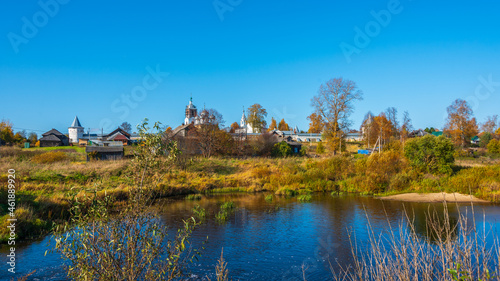 Autumn landscape with an ancient monastery in the background.
