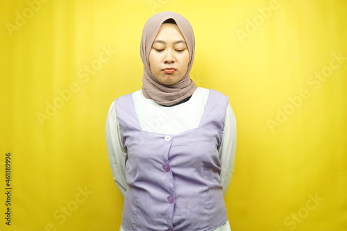 Beautiful asian young muslim woman pouting, disappointed, unhappy, dissatisfied, isolated on yellow background © MunirSr