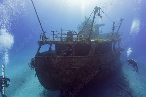 Photo SCUBA divers exploring a shipwreck in tropical waters