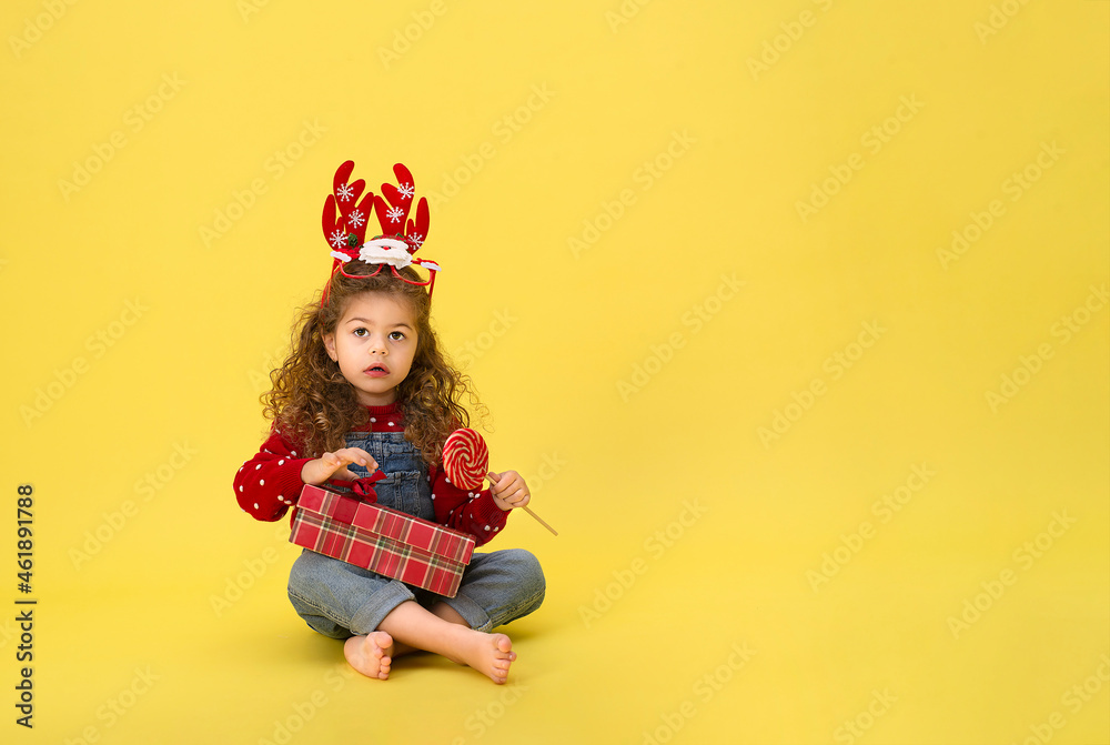 Portrait of happy little girl Christmas holding present box and looking at camera on yellow background
Portrait of happy little girl Christmas holding present box and looking at camera on yellow background