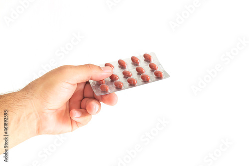 Man holding blister pack of pills isolated on white background photo