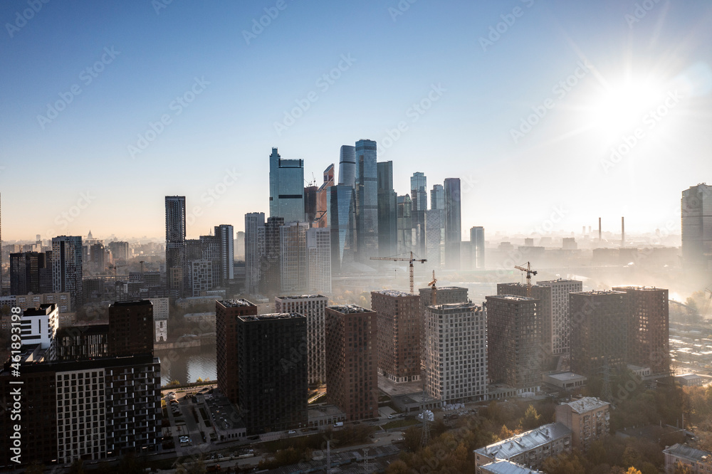 a panoramic view of the city business skyscrapers in the morning fog at sunrise filmed from a drone 