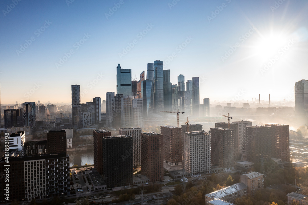 Fototapeta premium a panoramic view of the city business skyscrapers in the morning fog at sunrise filmed from a drone 