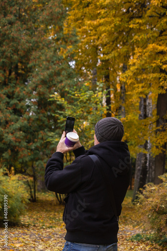 man taking pictures in the autumn forest