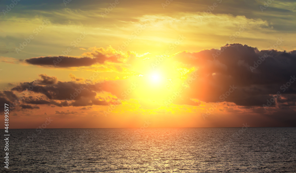 Fototapeta premium Sunset in a cloudy sky over the sea